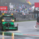 A truck tries to sweep rain off the race track in Belgium